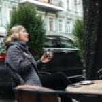 una mujer tomando café en una terraza de invierno